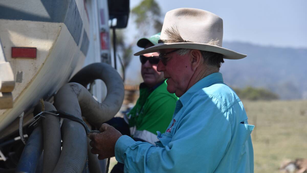 Mike Norton helps pump water into his drought-affected property. 