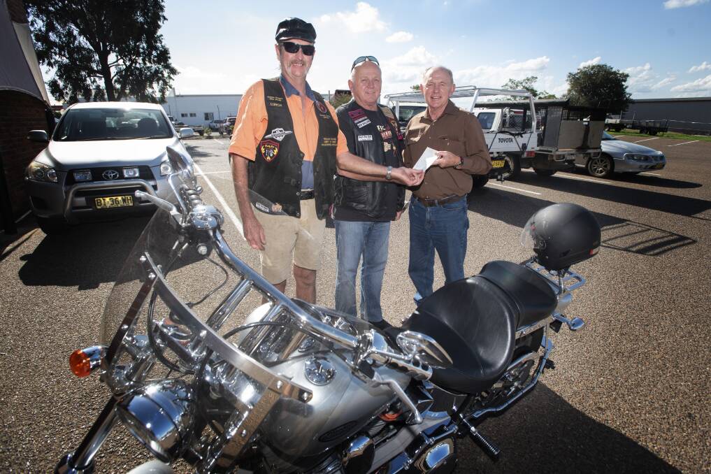 REV UP: Charity ride organisers Lurch and Noel Collins hand $5000 over to St Vincent de Paul's Paul Burton. Over 200 motorcycle enthusiasts from around NSW got together in Tamworth to raise the cash. Photo: Peter Hardin 180220PHG002