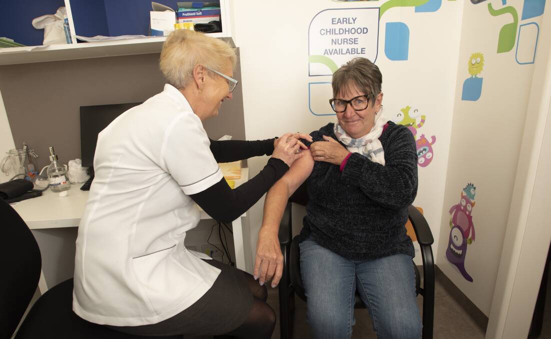Records broken: Karen Carter gives Gayle Downes the flu vaccine. Photo: Peter Hardin