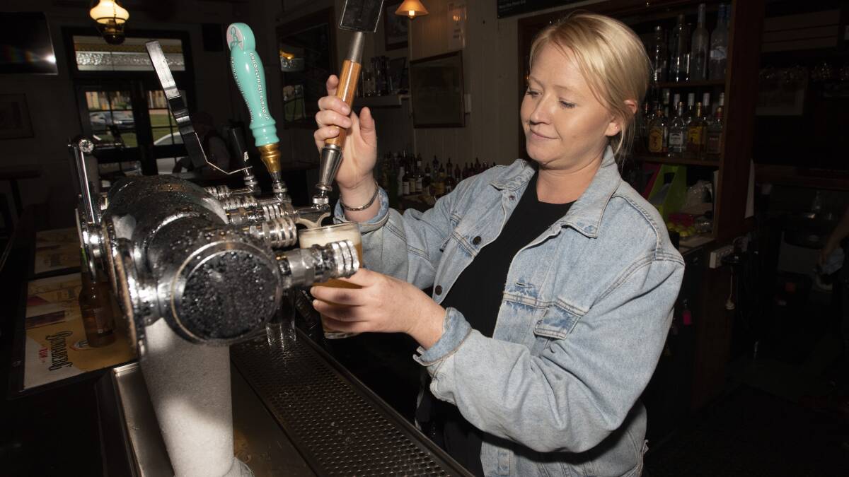 New normal: Pubs reopened last night for the first time in months, but a few things had to change. Maegan Watts pours a beer at the Tamworth Hotel. Photo: Peter Hardin