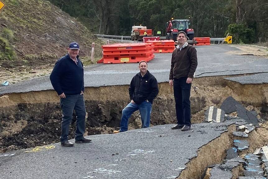 Upper Hunter mayor Maurice Collison, general manager Greg McDonald and MP David Layzell stand in a deep crack on the failed Merriwa to Willow Tree Road. Picture supplied