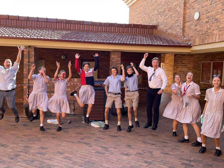 JUMP FOR JOY: Calrossy's last HSC class closes the books on their final exam on Thursday and jumps for joy with teacher James Vimpany and principal David Smith. Photo: Supplied