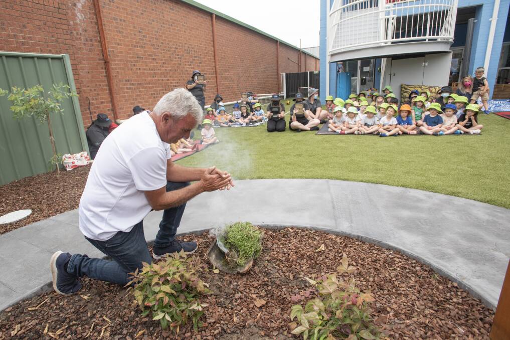 Len Waters completing a smoking ceremony in front of an intrigued crowd.