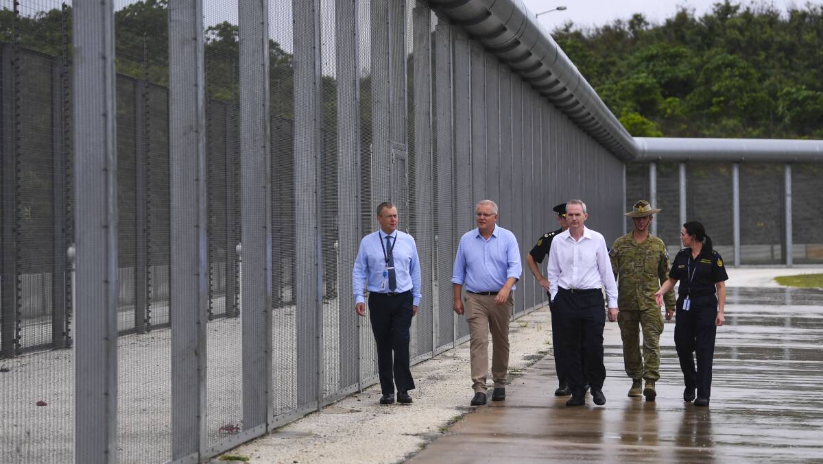 Prime Minister Scott Morrison is seen near the perimeter fence of North West Point Detention Centre on Christmas Island in March. Picture: AAP