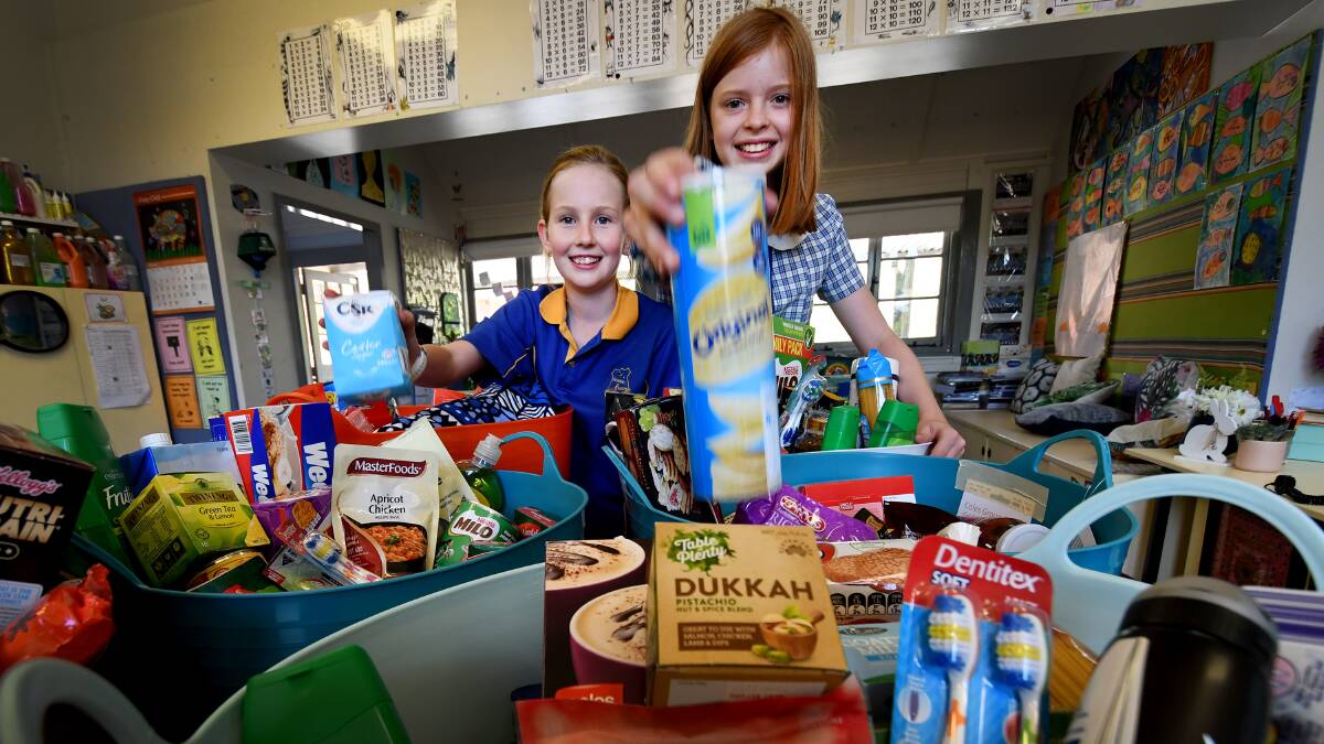 LITTLE LEGENDS: Friends and helpers Amelia Brown and Natalie Hanks with the hampers they plan to donate to farmers. Photo: Gareth Gardner 050319GGC03