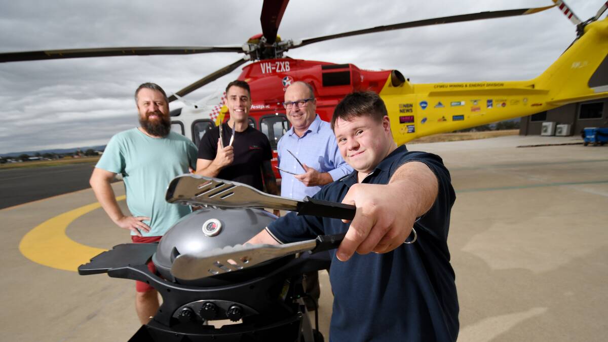 KINDNESS: Aaron Hemmings with his two carers Joe Dabron and Pat Burrows with Westpac Rescue Helicopter chief executive Richard Jones at the Tamworth base with the rescue helicopter. Photo: Gareth Gardner