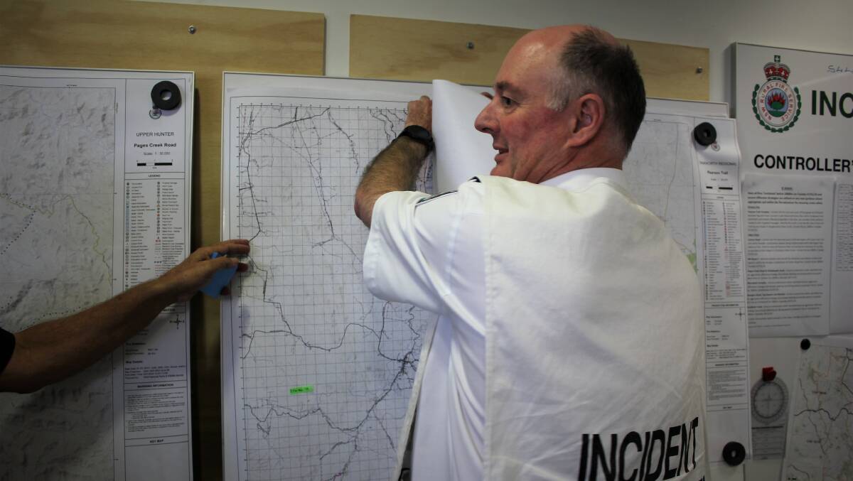 MAPPED OUT: Incident Controller Allyn Purkiss with new fire maps. Photo: Madeline Link