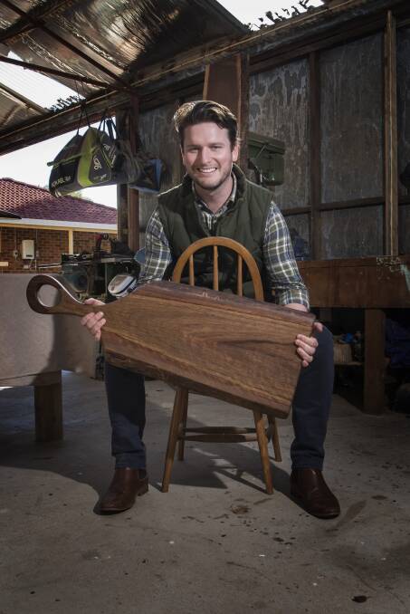 ARTISTRY: Woodworker Jack Massey with one of his large cheese boards made from Australian locally sourced wood. Photo: Peter Hardin 