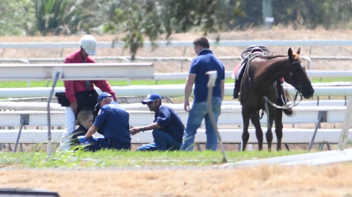 HORSE FALL: Paramedics were on scene to tend to the fallen jockeys after the domino-effect incident on Sunday. Photo: Gareth Gardner 100319GGB37