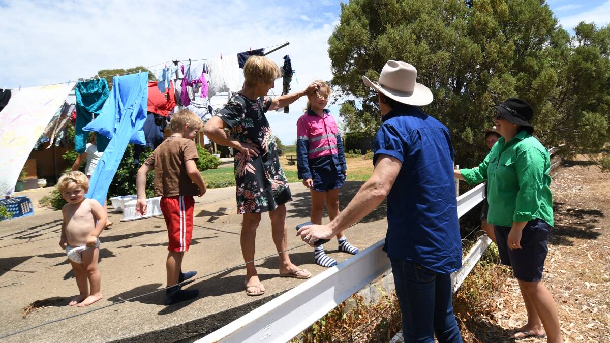 UNEXPECTED: Lee Kernaghan surprises Loomberah resident Janelle Tongue while she hands out her washing with the help of her grandchildren. Photo: Gareth Gardner