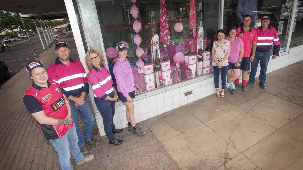 PRETTY IN PINK: Hart Rural Agencies staff with their done-up window display. Photo: Peter Hardin 121020PHB009