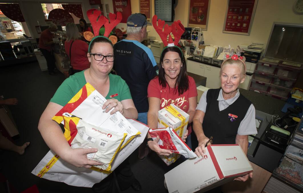 SANTA'S HELPERS: Tamworth Post Office staff Katie Slingsby, Tracey Lange and Victoria Davis send parcels off. Photo: Peter Hardin 201219PHB003