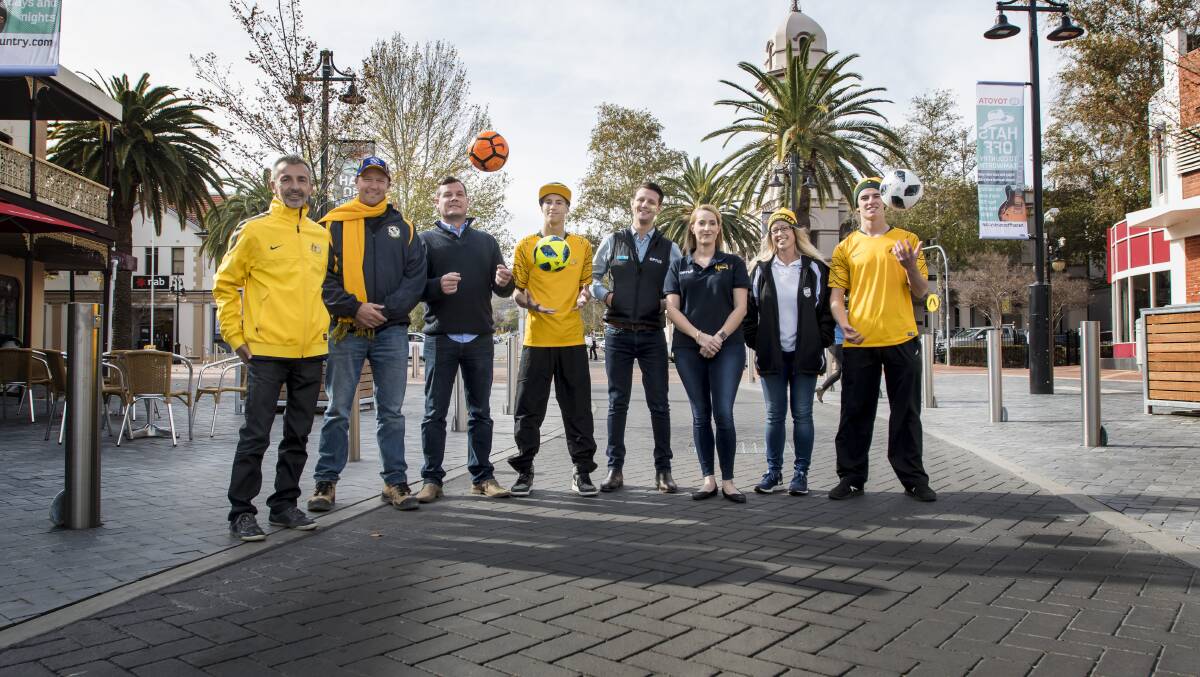 LET THE GAMES BEGIN: Football on Fitzroy event organisers and supporters in Fitzroy Arcade where the Socceroos game will be broadcast on Saturday. Photo: Peter Hardin