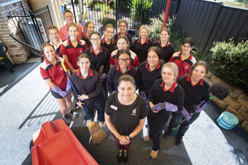 HELPING HAND: Calrossy Anglican School Year 10 students with Ronald McDonald House manager Rhiannon Curtis (centre). Photo: Peter Hardin 100521PHA014