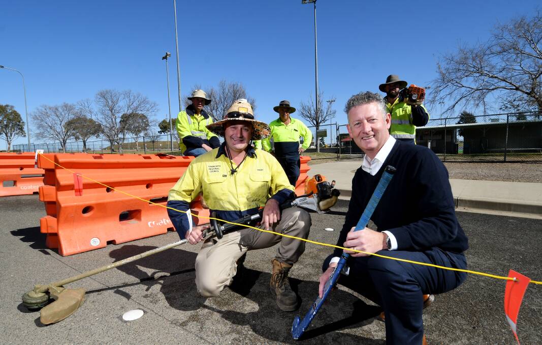 ALL THE ACTION: Council's Trent Harding, with Tamworth Hockey Association president Mark O'Connor, preparing the fields for the National Primary Games and York Cup and Kim Small Shield this weekend. Photo: Gareth Gardner