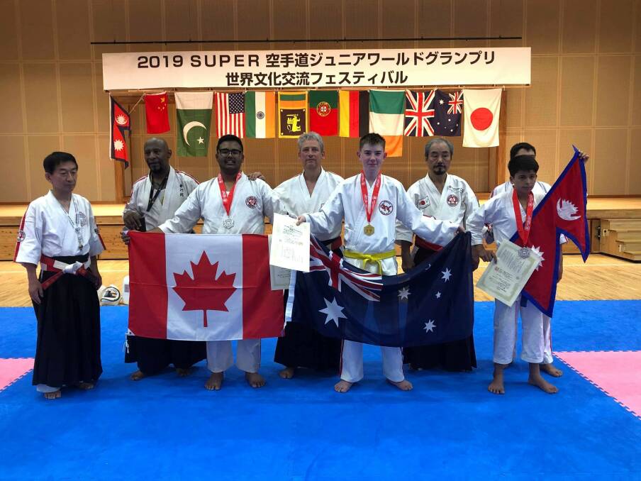 Honoured: Inverell's William Cripps holds the Australian flag as a new world champion. Photo: Supplied.