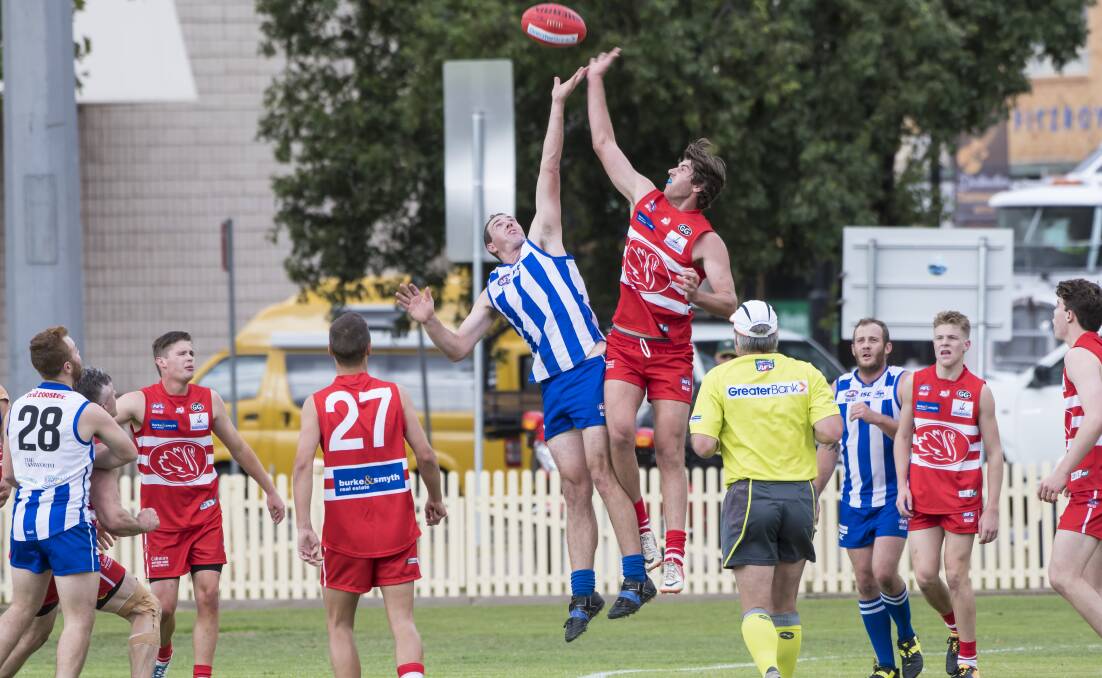 Soaring: Tamworth Kangaroos' Carl Frazier and Tamworth Swans' Adam Cruickshank compete for possession during Saturday's derby. Photo: Peter Hardin.