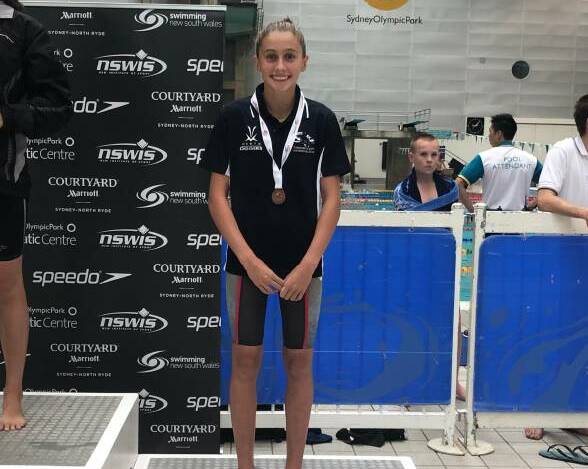 Alex Hayes, here receiving her bronze medal in the 200m breaststroke at the Country Championships, is one of five Tamworth City swimmers competing at the national age championships.