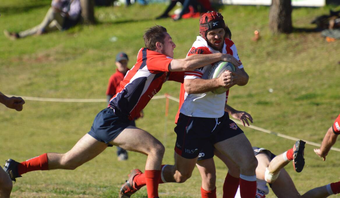Gunnedah five-eighth Marcus Hayne clings to Walcha opposite Simon Newton before the Red Devils defence eventually push him out. Photo: Samantha Newsam
