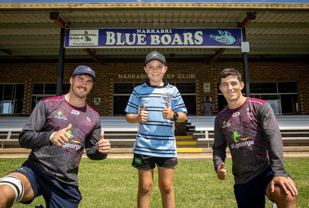 Raring to go: Jock Campbell (right) and Reds captain Liam Wright with a young Narrabri fan at Thursday's training run. Photo: Brendan Hertel/QRU