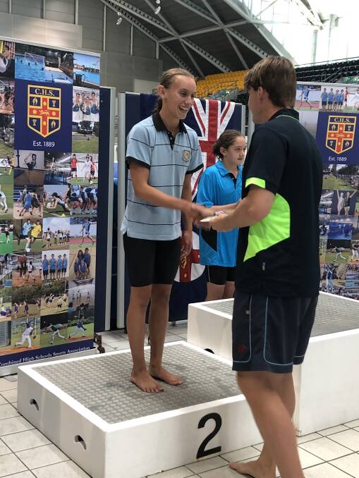 Kate Ibbott receives her silver medal for the 100m freestyle.