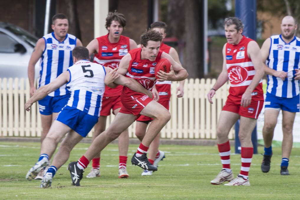 Tamworth Kangaroos' Chris Pollock attempts to stop Tamworth Swan's Liam Dunn as he surges through the middle during Saturday's derby. Photo: Peter Hardin