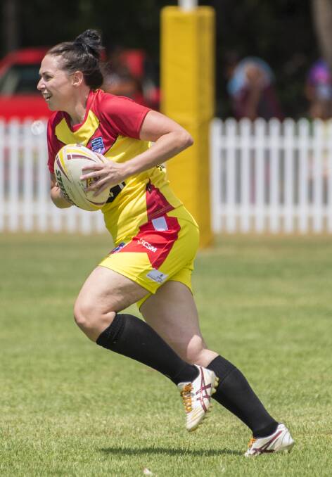 On the attack: Jess Brown runs the ball back strongly for the Rebels during their clash against Armidale on Saturday. Photo: Peter Hardin 180217PHB084