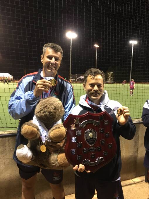 Golden success: Tamworth's Garry Littlejohns and Armidale's James Abbo with their gold medals and the silverware following their 5-2 win over Queensland.