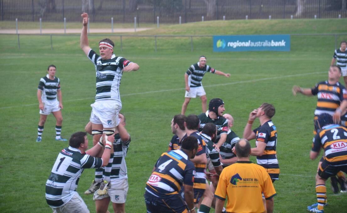 Soaring: Tom Menzies is hoisted high by his team-mates in this line-out during the students big win over Armidale on Saturday. Photo: Ellen Dunger