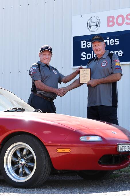 Thanks mate: Gundy Hunt (right) presents mechanic and good mate Trevor Osborne a plaque thanking him for his 50 years of support. Photo: Gareth Gardner