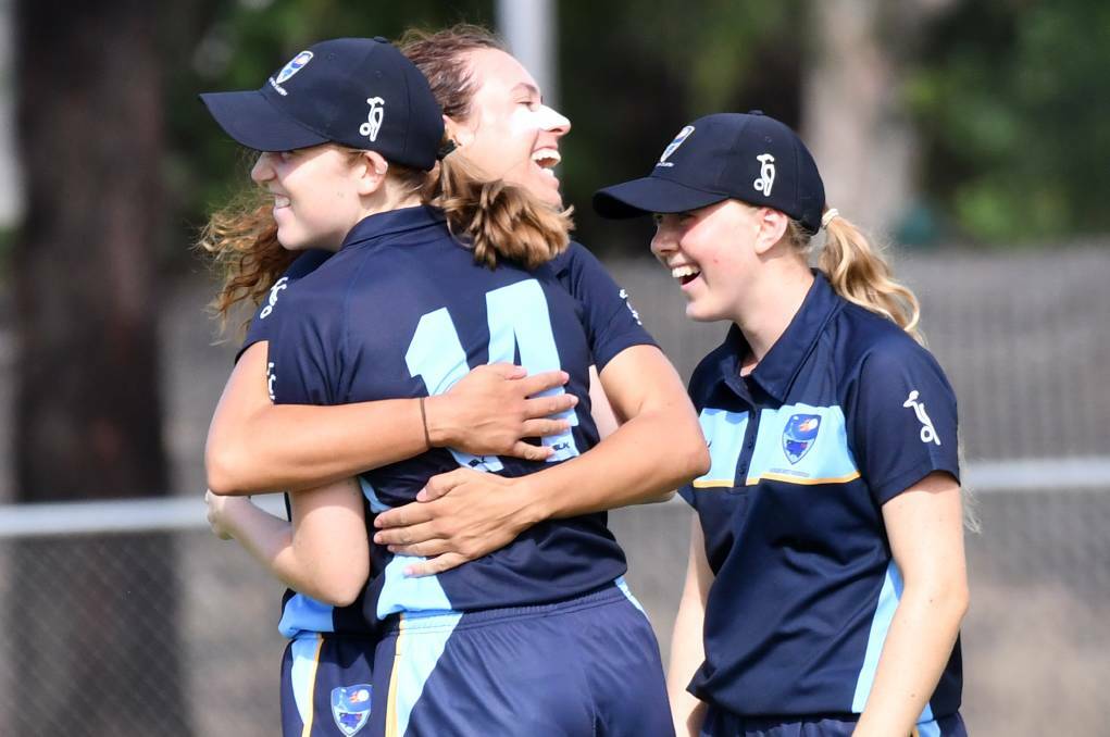 Lara Graham in the background as ACT/NSW Country celebrate a wicket. Photo: Darren Howe