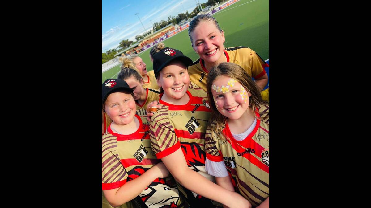 Alice Arnott, pictured here with some young fans during last year's Hockey One, has plenty of reasons of smile after being named in the Hockeyroos team to face India. Picture NSW Pride Facebook