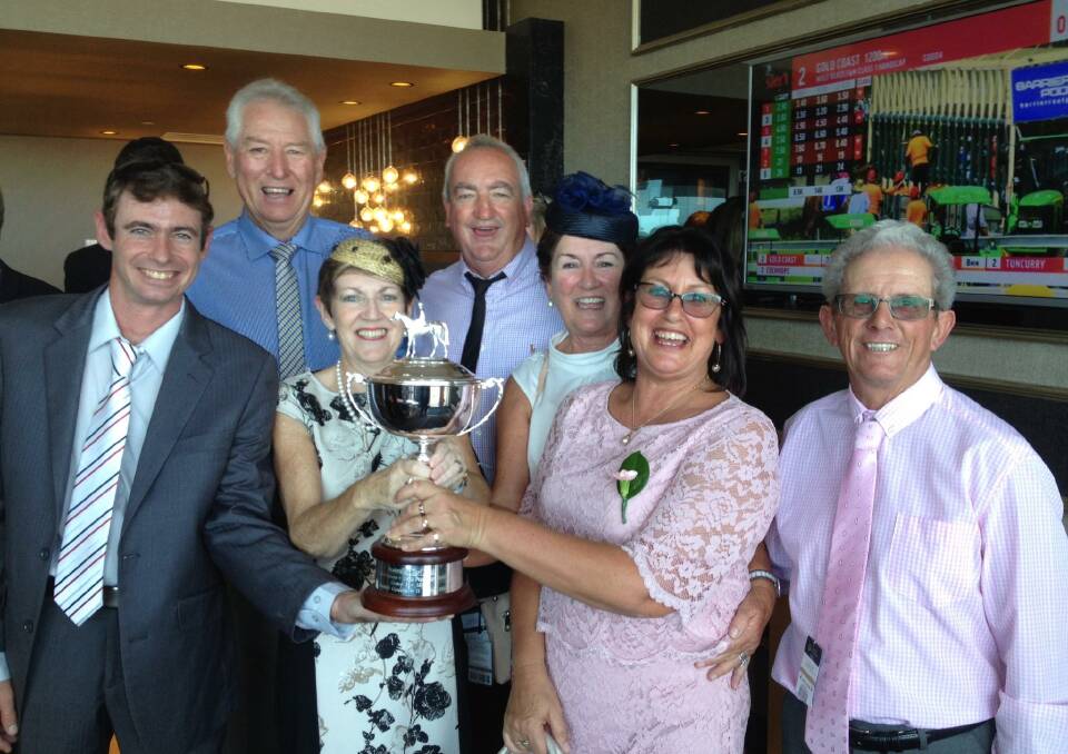 Leonie Johnson (black and white dress at the front) holds the Pago Pago trophy after Single Bullet's Golden Slipper-qualifying win.