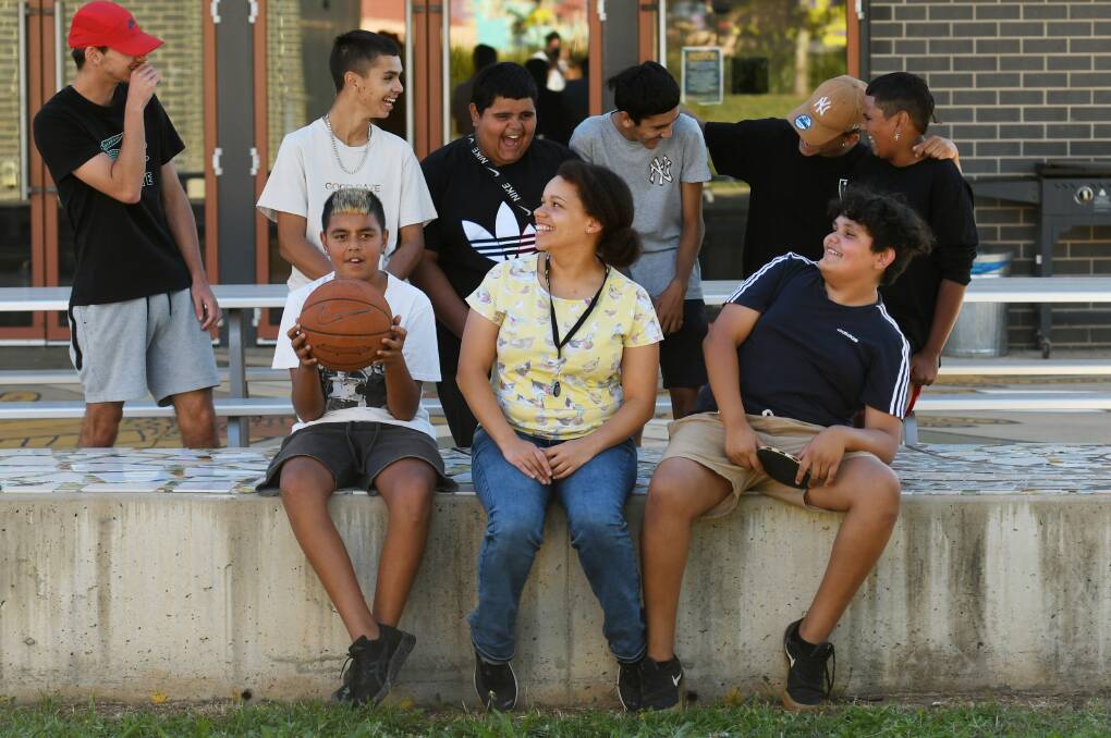 PLENTY OF FUN: Latrell Bird and Derrin Taylor and some of their mates sit alongside senior youth services assistant Sewa Emojong at The Youthie. Photo: Gareth Gardner