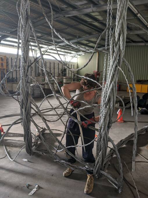 Lucy Irvine working with steel cables.