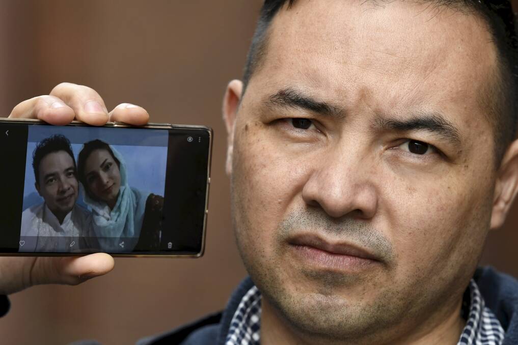 Nadir Heidari with a picture of he and his wife Zahra who is trapped in Afghanistan with their 11-month-old son. Picture: Lachlan Bence