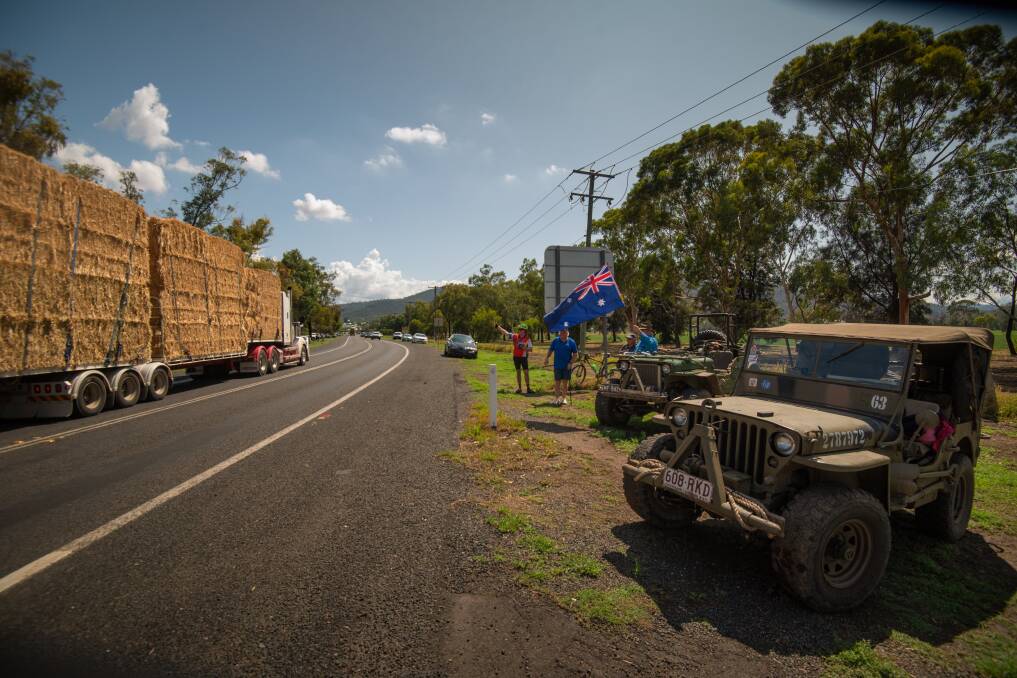 HAY RUN: Carl Flannery of Tamworth and Ken Hurling OAM of Brisbane parked their vintage Jeeps, which they have taken around the country, to wave in the hay runners on Scott Road on Saturday with David Sampson and Bruce McLean. Photo: Simon McCarthy