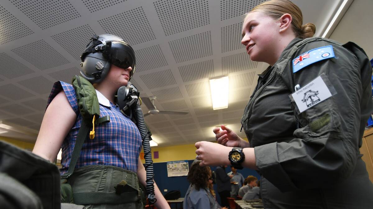 GEARED UP: Oxley High student Alira MacAlpine gets the run down from RAAF Pilot Officer Sophie Winterton as part of an immersive air force experience in Tamworth. Photo: Gareth Gardner 311018GGB03