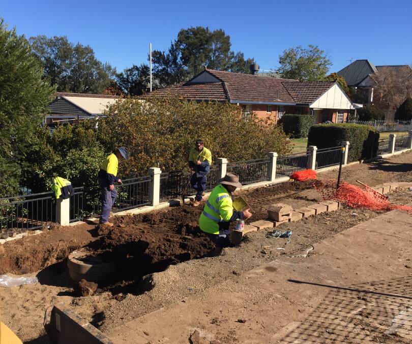 DIGGING IN: Crews repair a a ruptured water main on Armidale Road which burst and inundated eight houses. Photo: Jacob McArthur