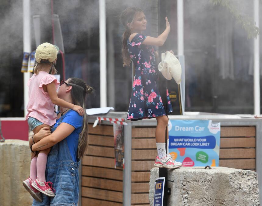 MIST ME: Some folks cool off on Peel Street during the Tamworth Country Music Festival. Photo: Gareth Gardner 220119GGB08