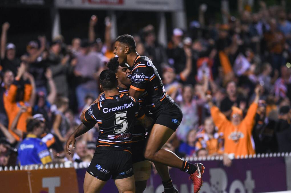 SCORE: Wests Tigers' players embrace in Tamworth during their historic clash earlier this year. Photo: Gareth Gardner 210418GGD051