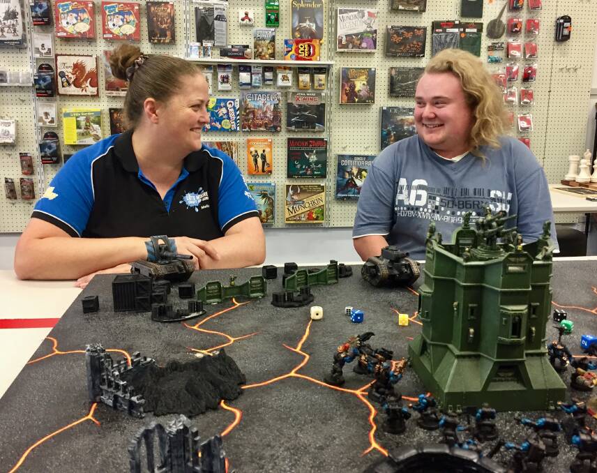 GAME ON: Lots Moore Gaming owner Melissa Moore and customer Ben Kotwa at one of the Warhammer tables. Photo: Jacob McArthur 160118JMA01