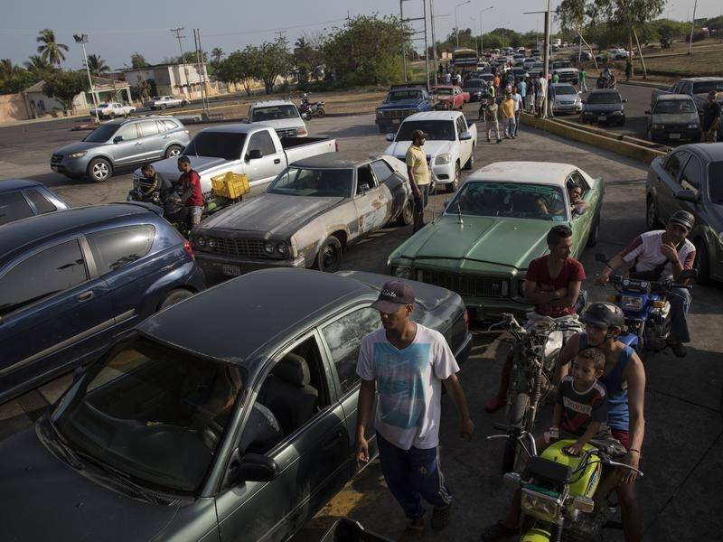 Venezuela drivers are queuing amid a petrol shortage exacerbated by US sanctions and old refineries.