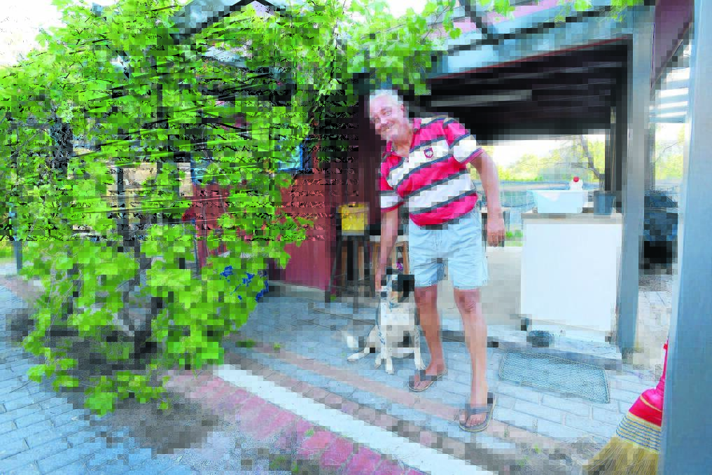 HOME SWEET HOME: Dennis and his dog Rocky settle into their new accommodation after months living in a car. Photo: Barry Smith 061014BSD04