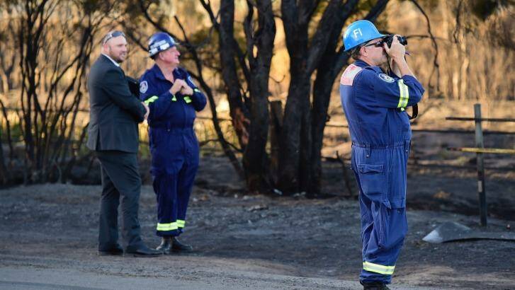 Fire investigation crews inspect the scene on Vincent Road in Llandilo where it is thought the fire began. Photo: Wolter Peeters