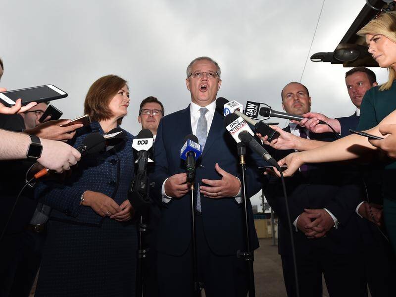 Police made a protester throw away a carton of eggs before Scott Morrison(C)announced a rail project