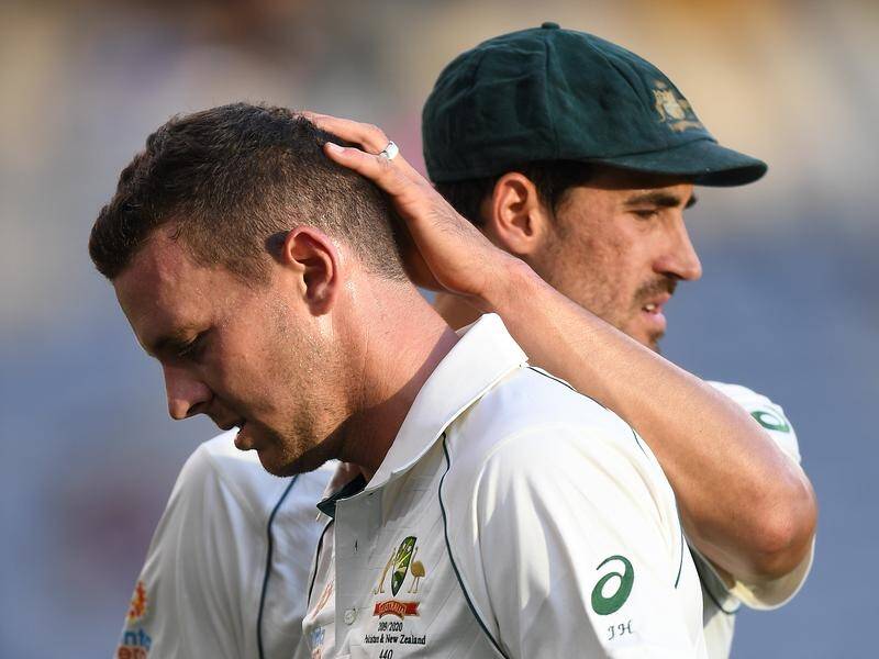 Josh Hazlewood is consoled by Mitchell Starc after straining a hamstring in the first Test in Perth.
