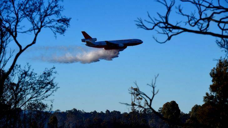 The rural fire service's DC-10 water bombing aircraft dumps its load along Cranebrook Road. Photo: Wolter Peeters