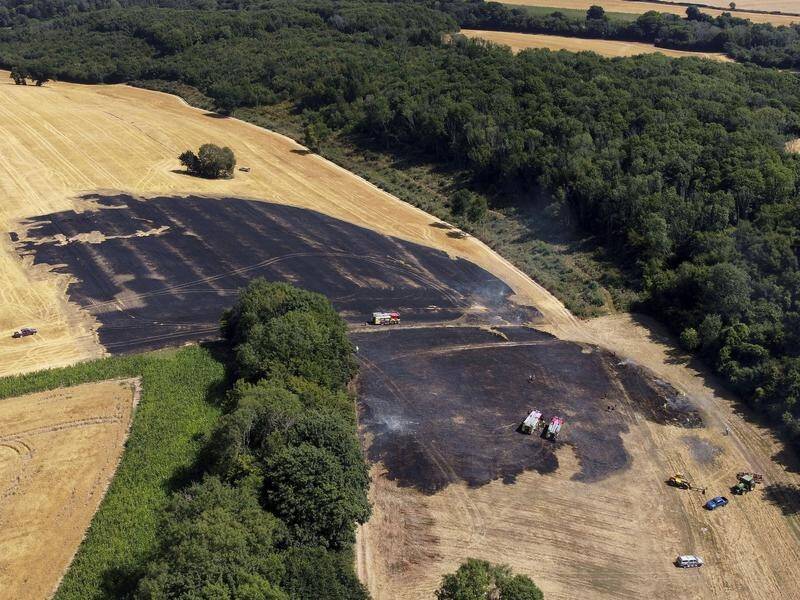 A field fire is brought under control near Ashford in southern England as Europe's heatwave goes on. (AP PHOTO)