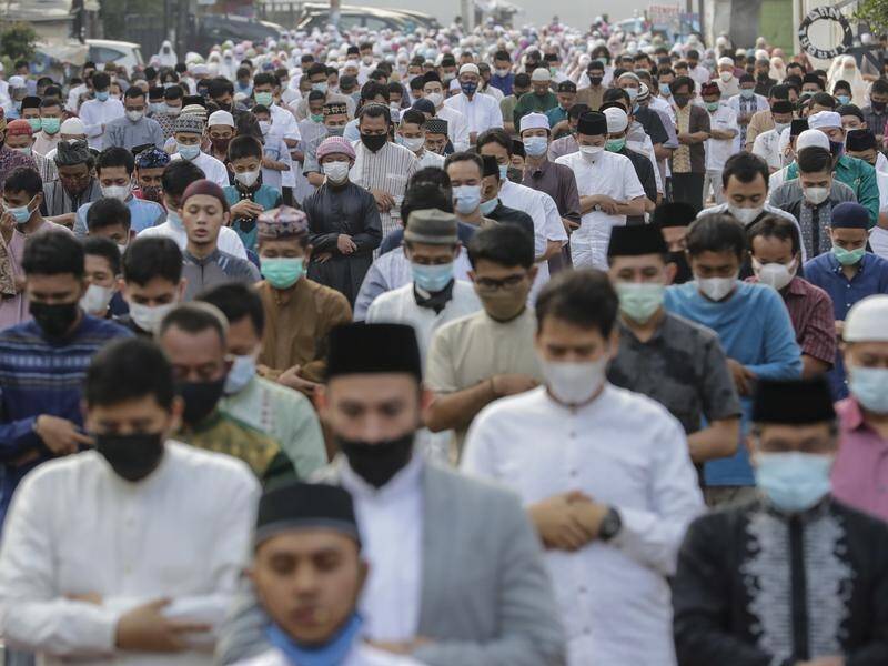 Worshippers wearing masks joined communal prayers in the streets of Jakarta for Eid al-Fitr.